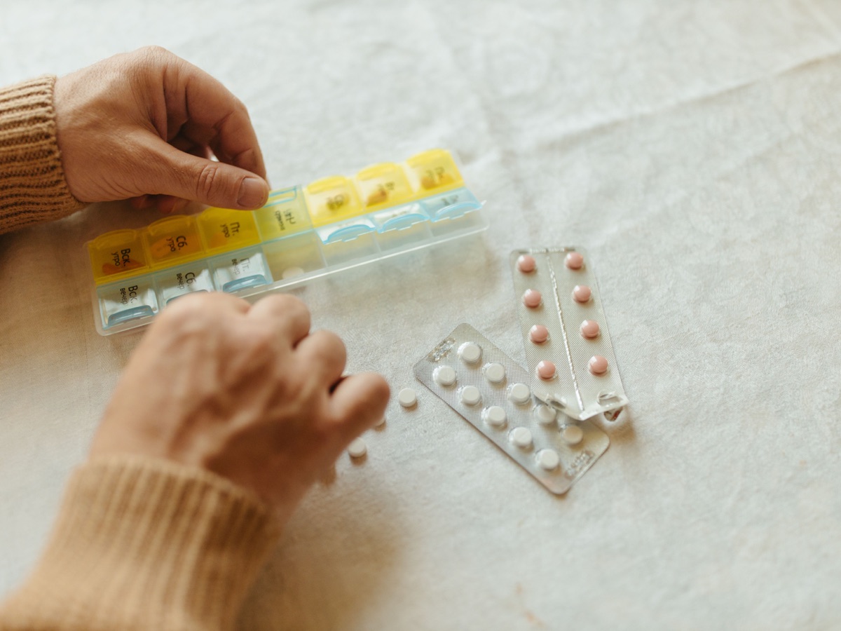 Patient organizing medication in a weekly pillbox