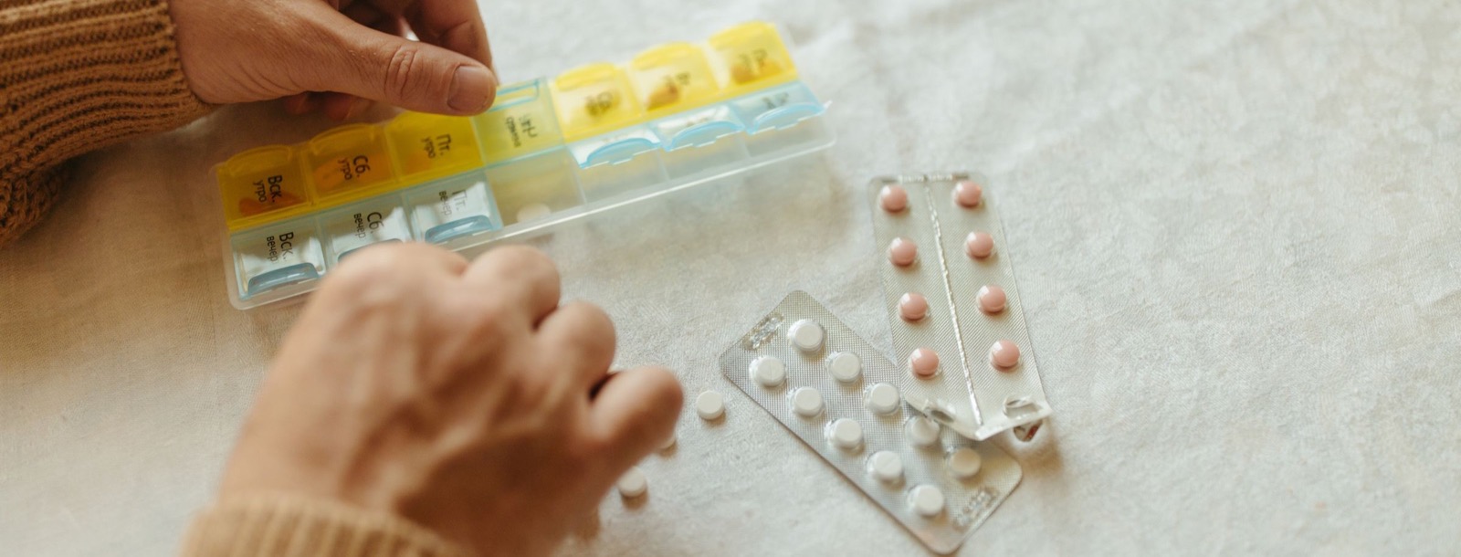 Patient organizing medications in a weekly pillbox
